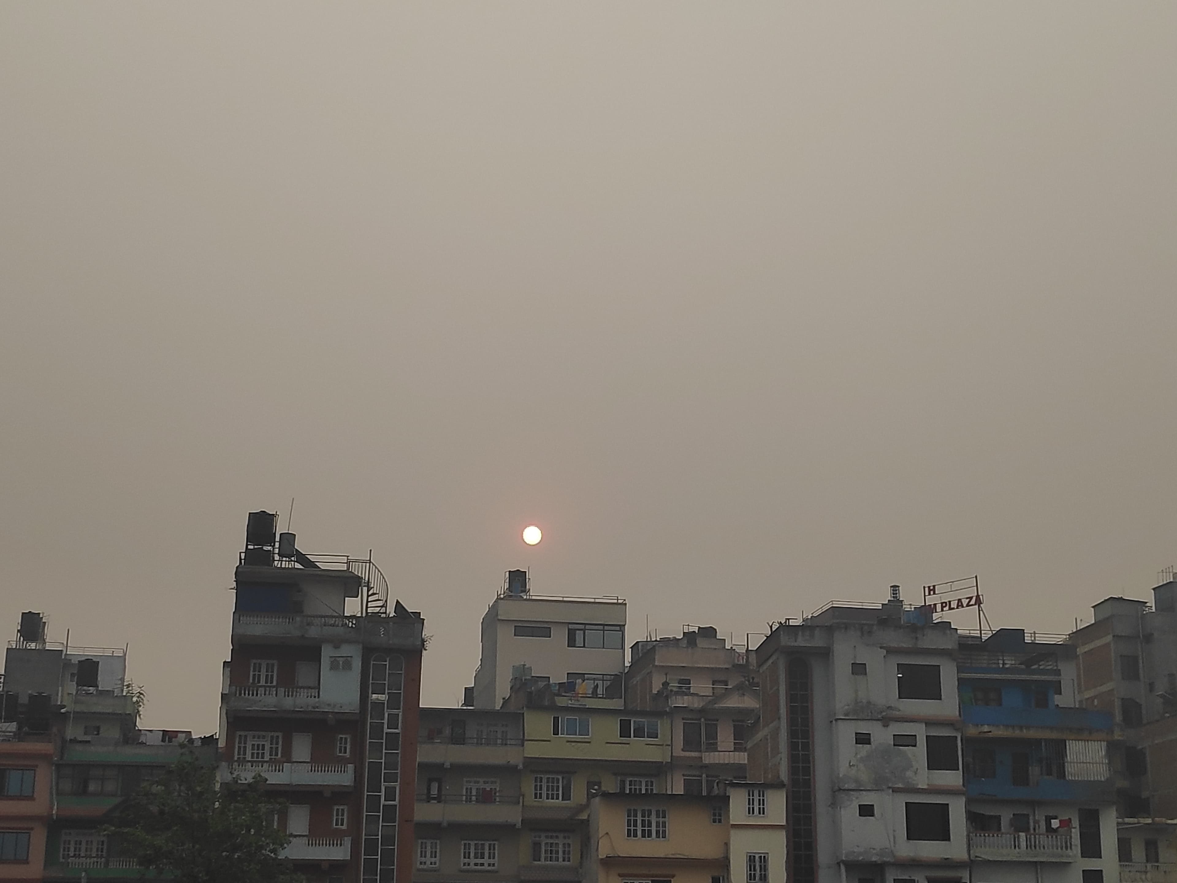 A picture of polluted sky with houses in front